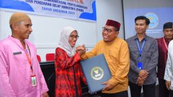 Asisten Sekda Bidang Administrasi Umum Yakub Husain menyerahkan penghargaan kepada Nurani Husen sebagaipenggiat terbaik anti Narkoba di Kelurahan Cobodoe (2)